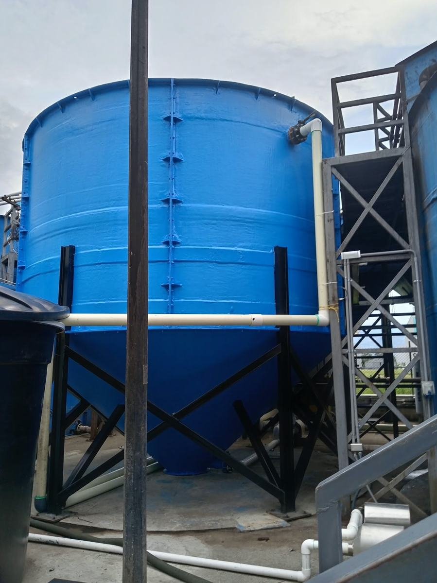 Tanque en fibra de vidrio pintado de azul sobre estructura metálica soldada y escalera industrial